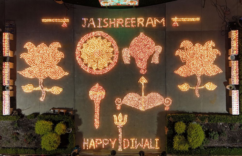 Diyas arranged into lotus and om shapes, spelling Happy Diwali